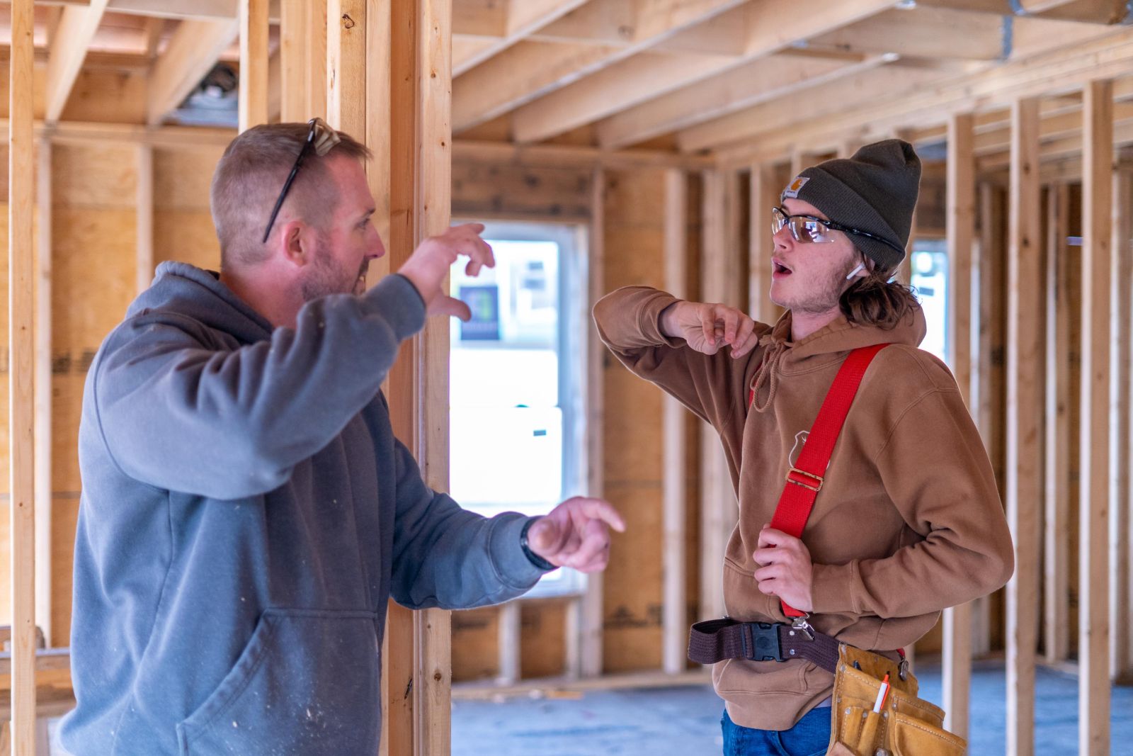 two guys talking while working on house project