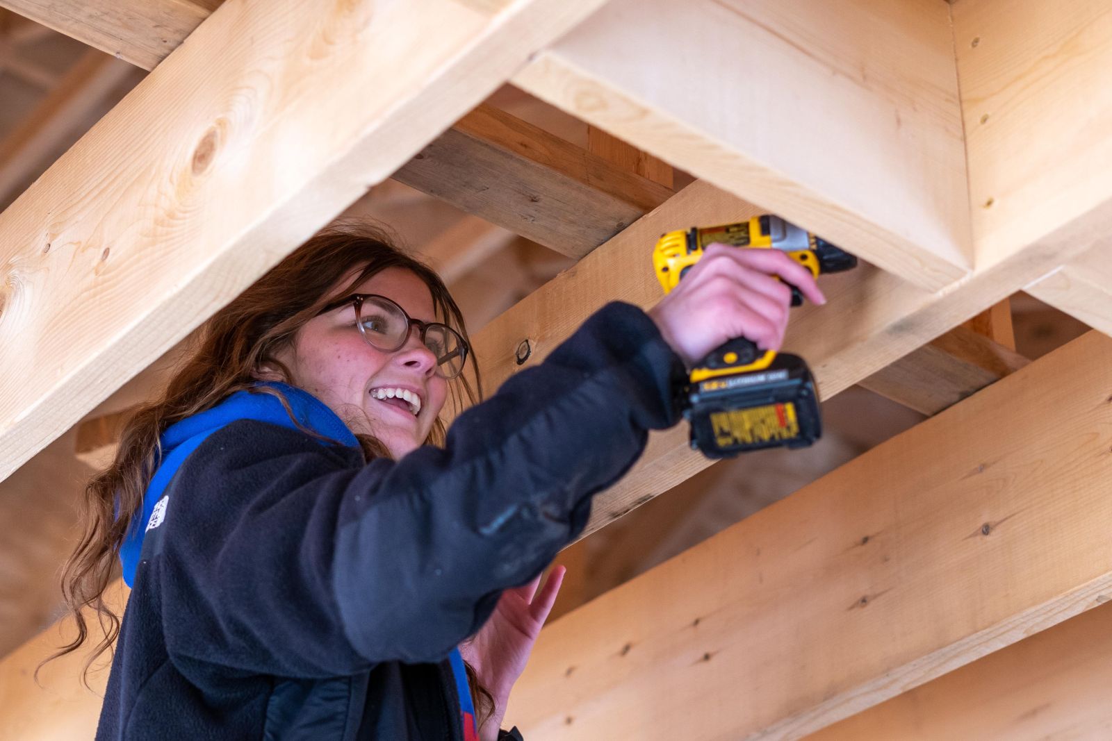 girl holding drill working on house project